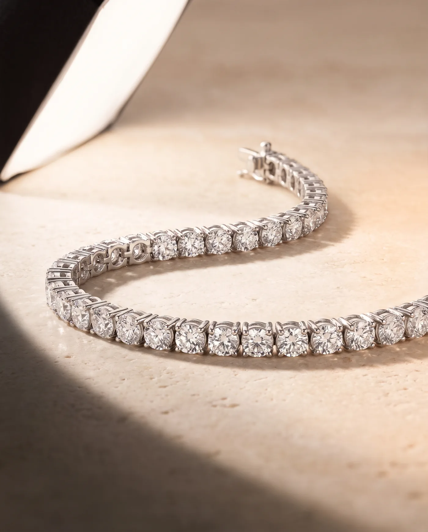 An 18k white gold tennis bracelet, a continuous line of round brilliant diamonds in four-prong settings