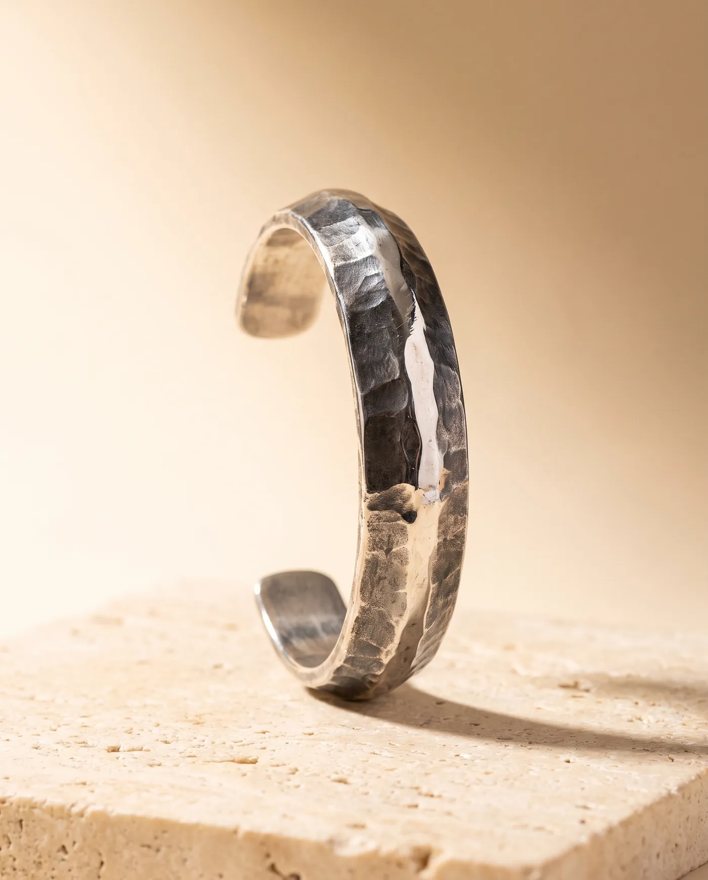 A hand-raised sterling silver cuff, its planished surface catching the light