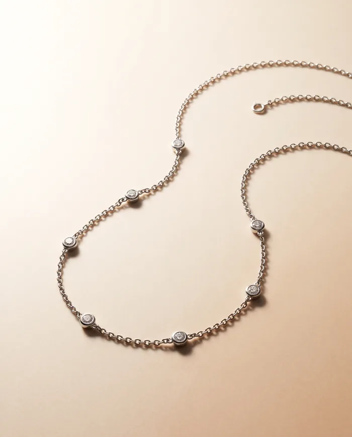 A delicate 18k white gold chain set at even intervals with small round brilliant diamonds in flush bezels